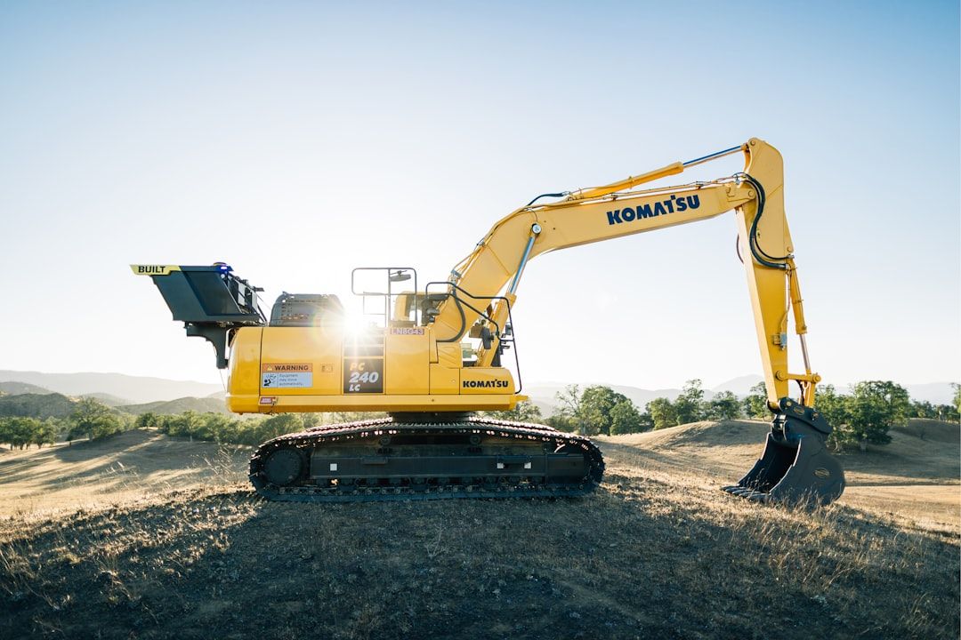 Gelber Komatsu PC 240 LC Kettenbagger auf einem Hügel.