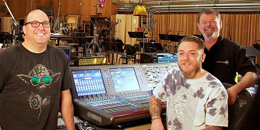 Vier Männer neben einem digitalen Yamaha-Mischpult im Tonstudio