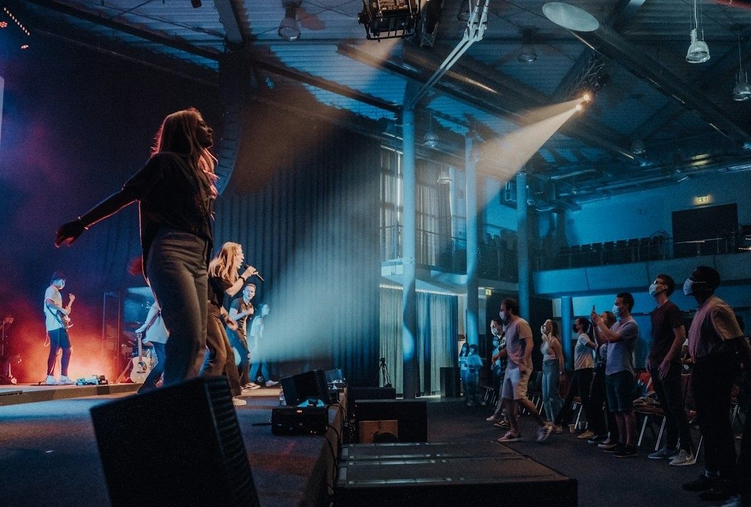Liveband auf Clubbühne vor tanzendem Publikum bei blauem Bühnenlicht